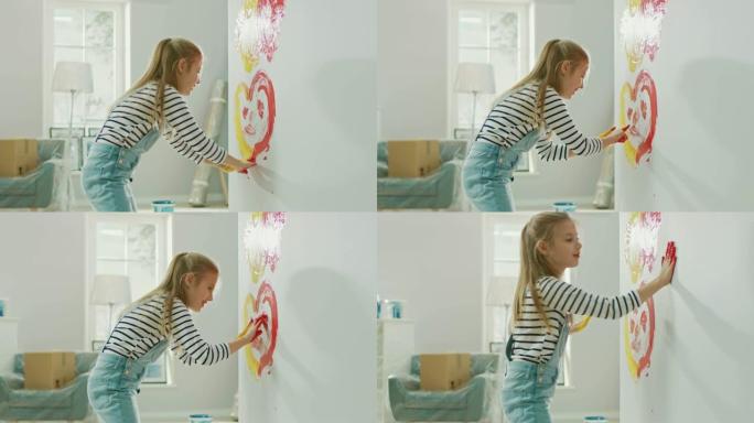 快乐的小女孩用手蘸上黄色和红色的油漆，在墙上用微笑画出五颜六色的心。她玩得很开心，笑得很开心。家正在