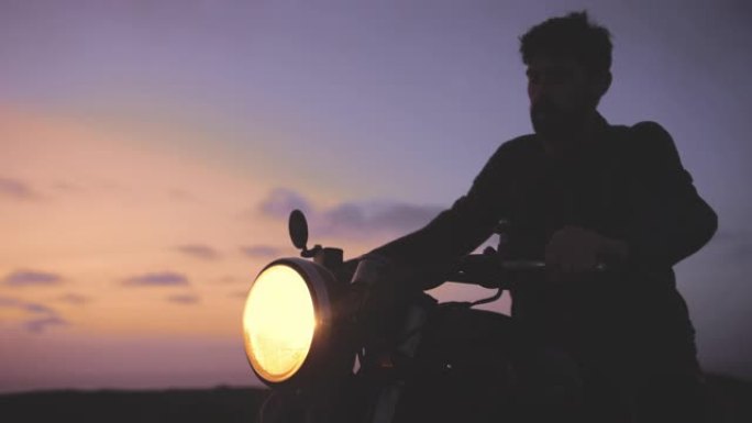 日落时分，一名男子骑着经典摩托车离开
