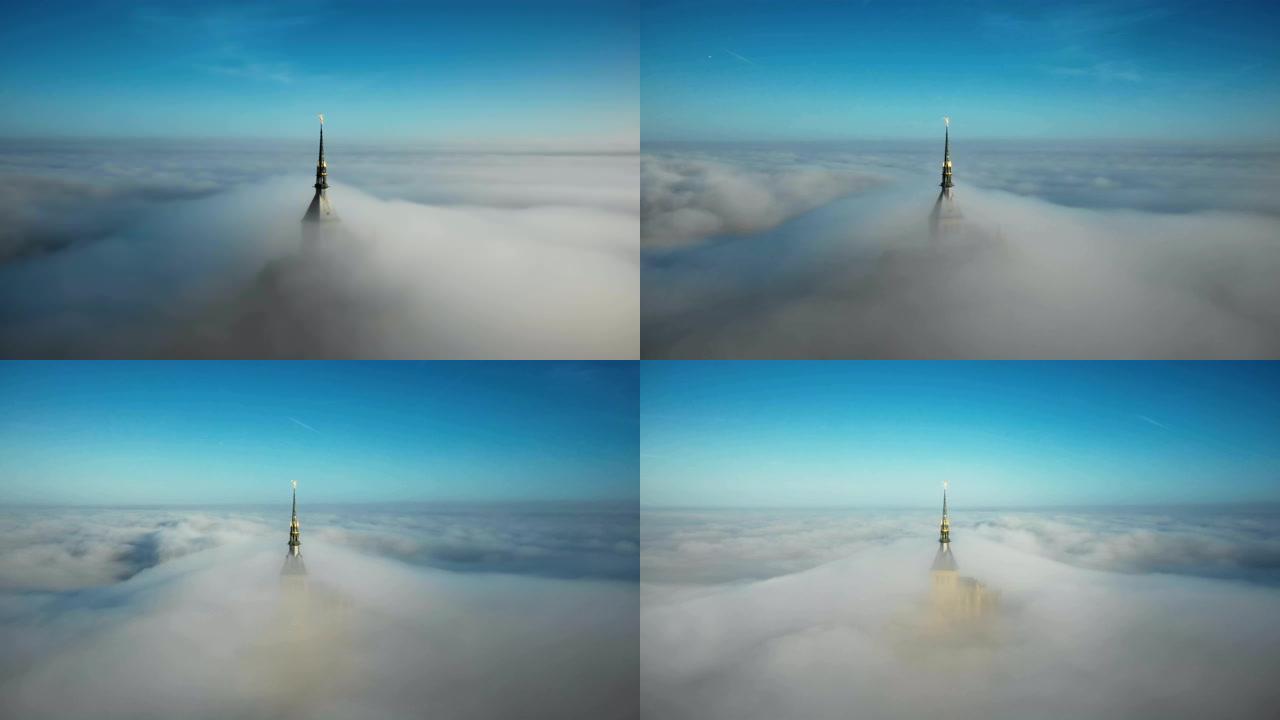在史诗般的日出雾云下，无人驾驶飞机在诺曼底圣米歇尔山城堡空灵的金色修道院尖顶周围飞行。