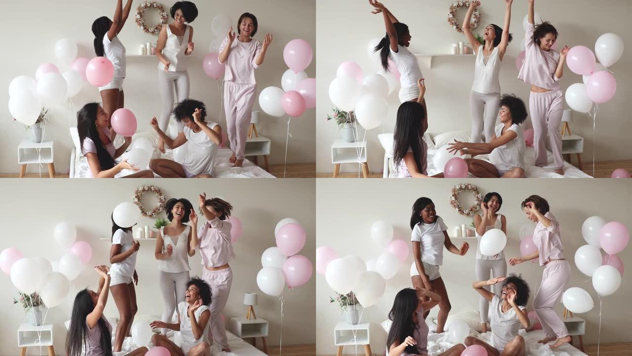 兴奋的性感多样的女士在床上跳舞用气球庆祝