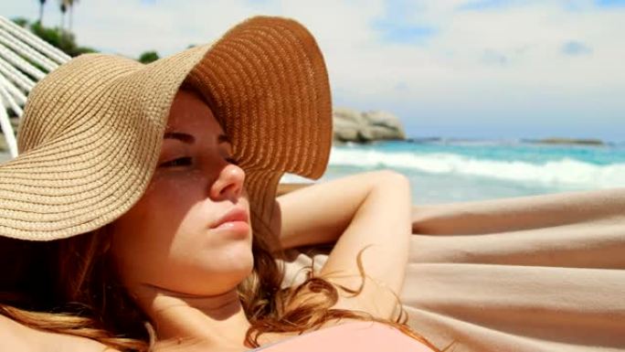 白人妇女在4k海滩的吊床上放松的前视图