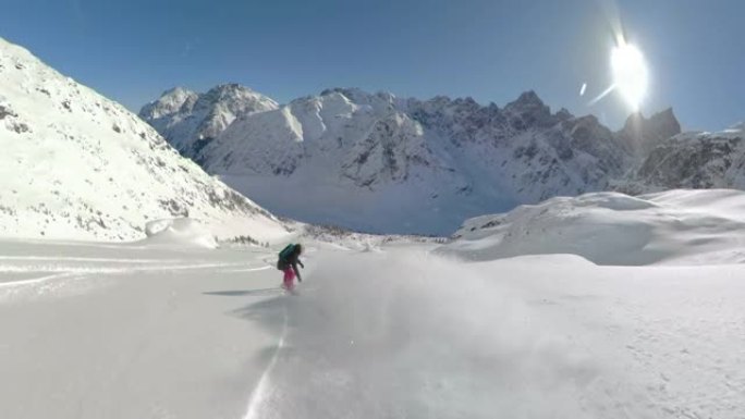 以下是: 女性滑雪者在阳光明媚的日子里在未触及的山上雕刻。