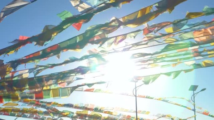 太阳耀斑: 明亮的阳光透过一堆五颜六色的祈祷旗闪耀。