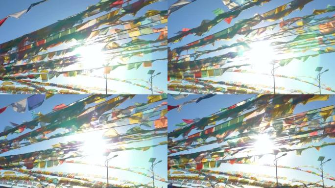 太阳耀斑: 明亮的阳光透过一堆五颜六色的祈祷旗闪耀。