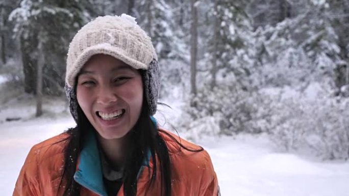 亚洲妇女在雪地里看着相机