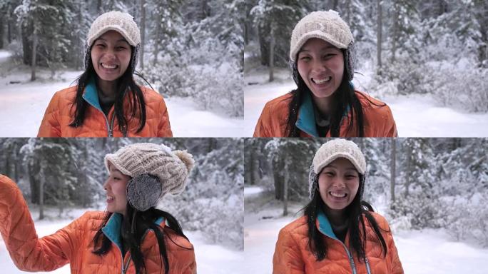 亚洲妇女在雪地里看着相机