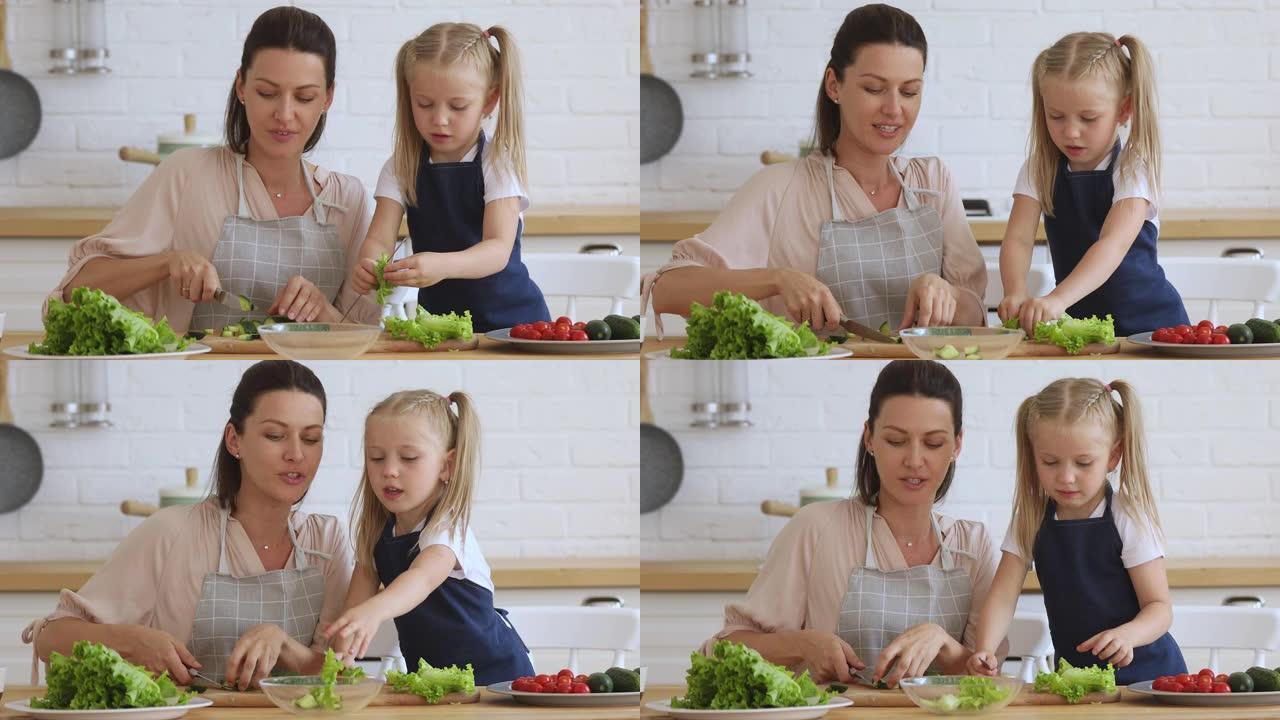 30多岁快乐的女人教小女儿准备健康的素食。
