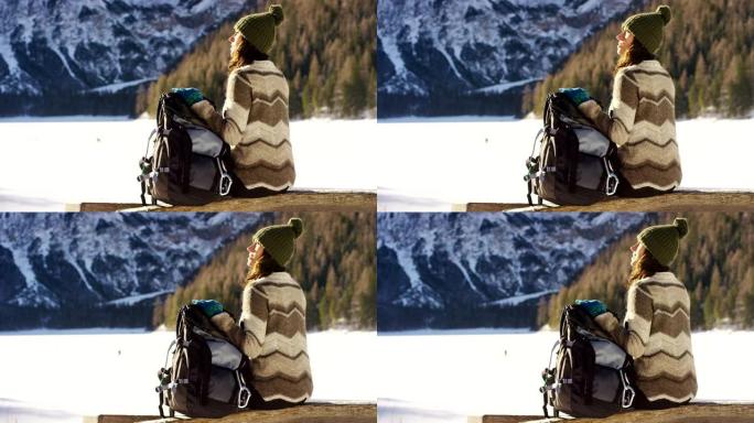 女人拿着背包仰望雪山