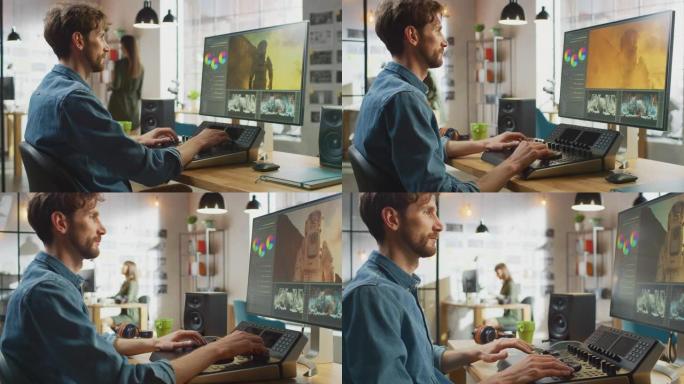 带有胡须和牛仔裤衬衫的男性视频编辑器使用编辑控制台甲板在他的个人计算机上处理镜头。他在一个很酷的办公