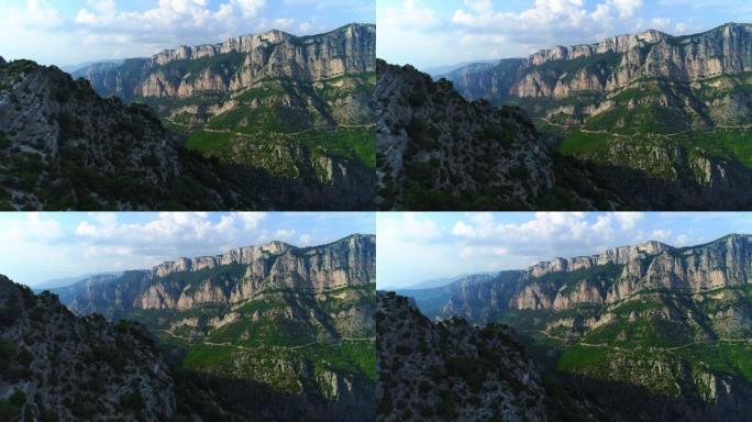 在晴朗的晴天，晴朗的蓝天下，山峡谷的空中电影无人机视图经过。法国美丽的维登峡谷山谷。夏季绿色乡村的俯