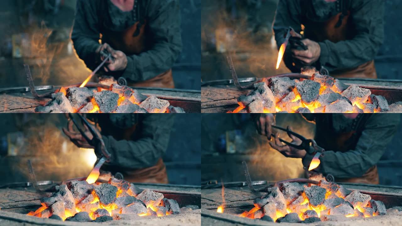 一个人在锻造厂工作，加热金属刀。