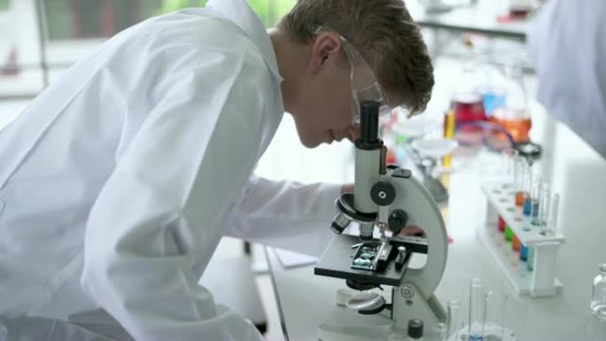 理科学生在显微镜下观察载玻片