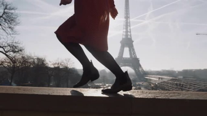 电影特写，穿着红色连衣裙的美丽幸福女人的腿在浪漫的埃菲尔铁塔全景慢动作附近奔跑。