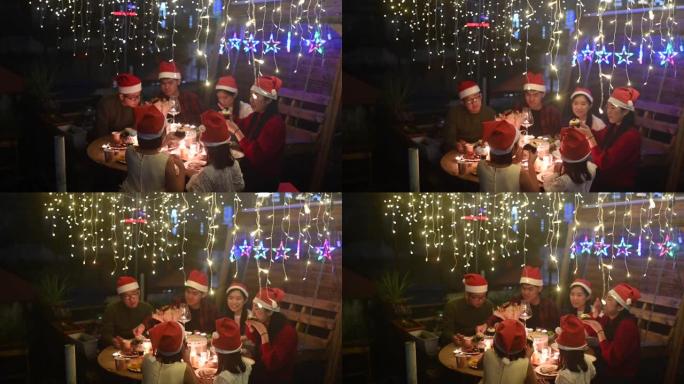 亚洲华人家庭庆祝圣诞派对晚宴在他们家前院举行，餐桌上有圣诞烛光，在感恩节晚宴上定下珍贵的家庭时光
