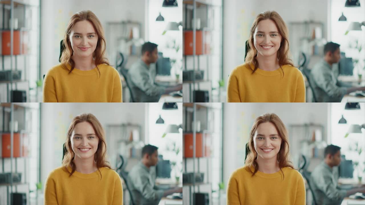 穿着黄色毛衣的红头发的美丽年轻女子的肖像迷人地对着镜头微笑。在明亮多样的办公室工作的成功女性