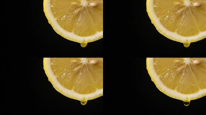 慢动作: 柠檬片上的一滴液体在黑色上