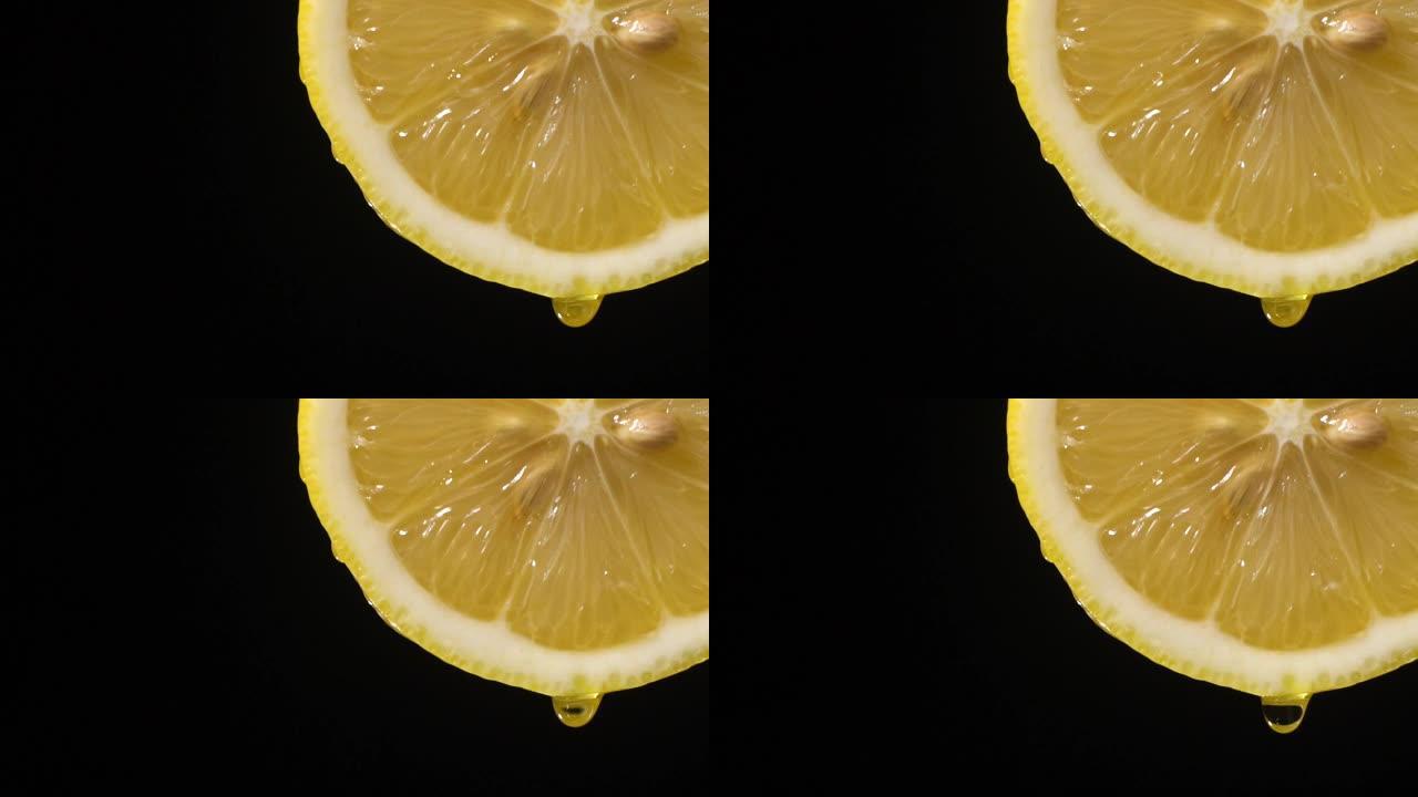 慢动作: 柠檬片上的一滴液体在黑色上