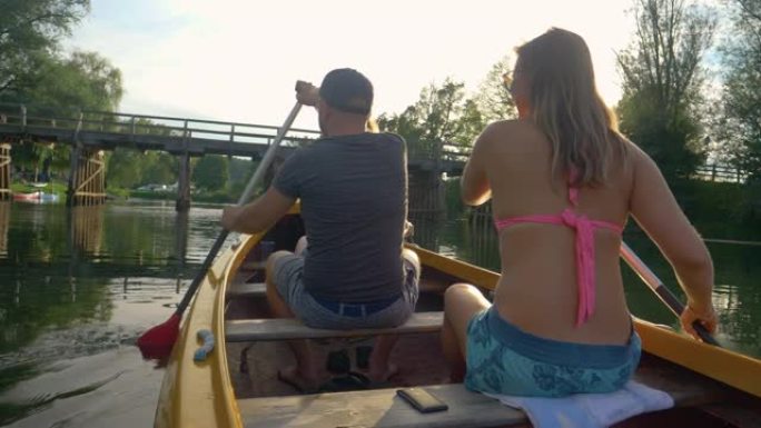 镜头耀斑: 金色的夏日阳光照耀着两名划着独木舟的游客。