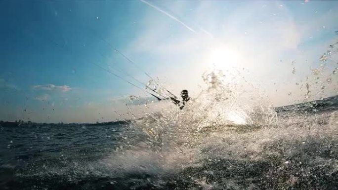 一个人在风筝冲浪时，水在飞溅