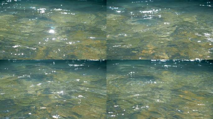 干净的水胡言乱语，特写。光线从中反射的水面。