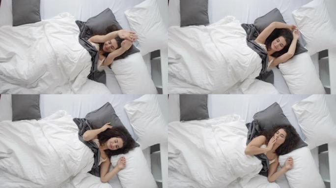 调情的女人在床上伸展并摆姿势拍照