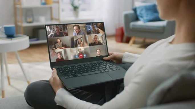 家庭办公室: 女人使用带有会议视频通话应用程序的笔记本电脑与朋友，亲戚和同事聊天。远程工作，家庭办公