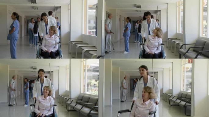 美丽的女医生推着轮椅与女高龄患者交谈时非常愉快地走在医院的走廊上