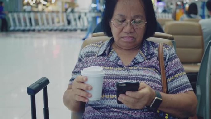 在机场使用智能手机的高级女性