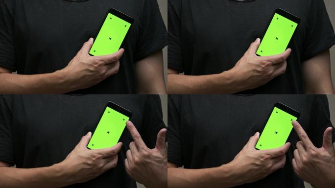 穿着黑色t恤的亚洲男子拿着绿色屏幕的智能手机，并指向屏幕。