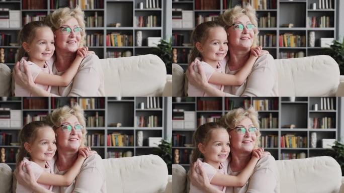 微笑的老奶奶拥抱保护可爱的孙女看着做梦