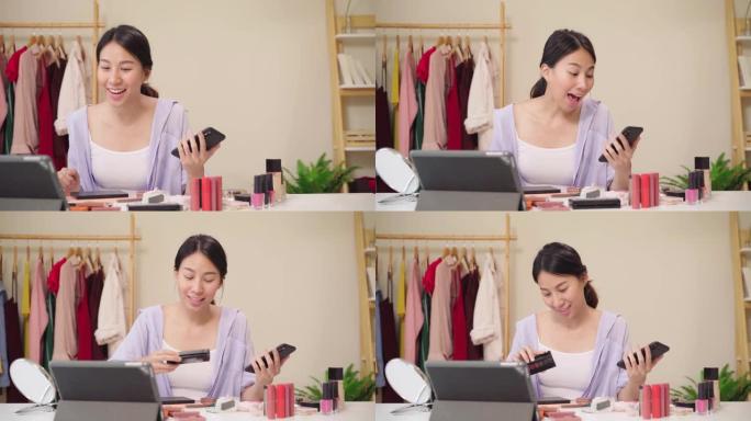 美容博主问答坐在平板电脑前录制视频的电话。快乐美丽的年轻亚洲女人使用化妆品评论化妆教程直播视频到社交
