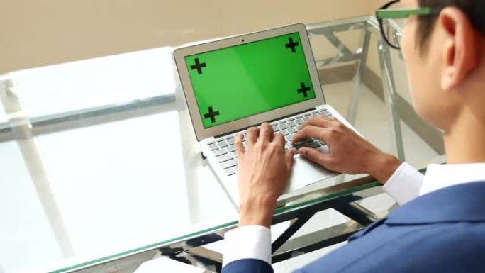 商人使用带有绿屏的笔记本电脑