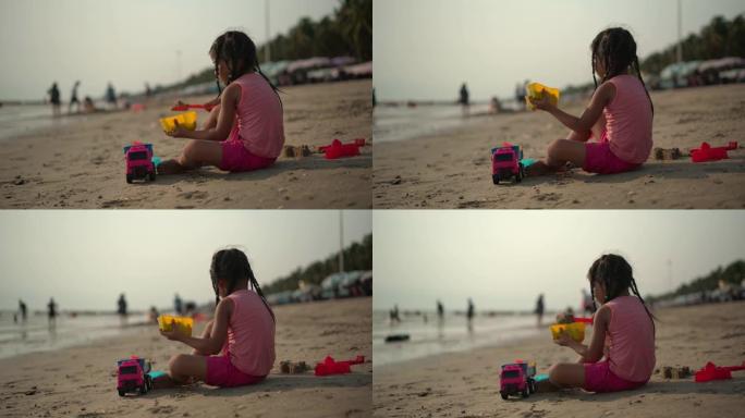 女孩在海滩玩沙子和玩具