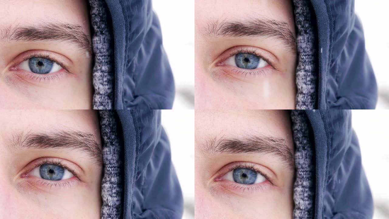 一个男人的蓝眼睛在房间里看着，而雪从空中以慢动作落下。