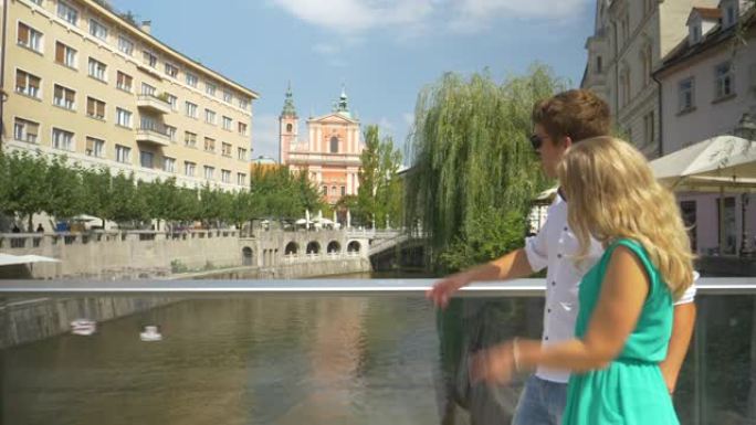 复制空间: 年轻夫妇在探索卢布尔雅那时漫步在桥上。