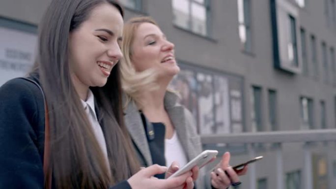 带着智能手机穿越城市行人天桥的快乐年轻女商人朋友