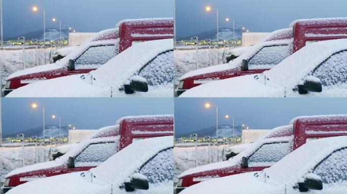 在阿根廷乌斯怀亚的冬季暴风雪中停放的被雪覆盖的汽车。