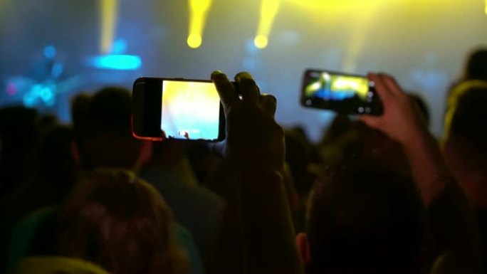 MS人群中带着照相手机跳舞和拍摄音乐音乐会