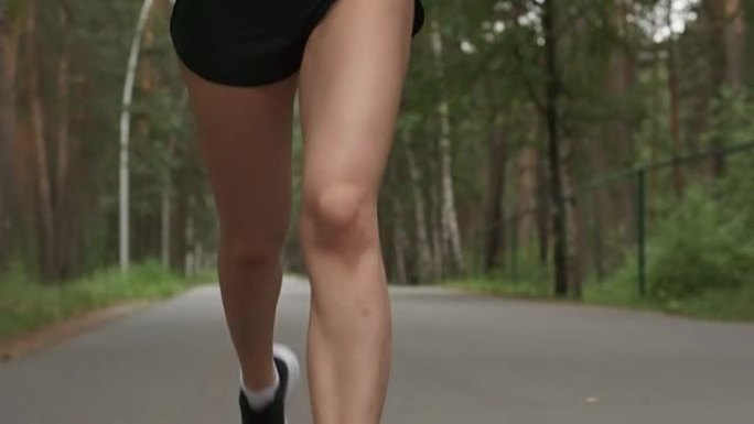 适合女运动员沿着森林路慢跑