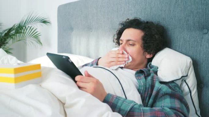 生病的人在家里使用数字平板电脑。