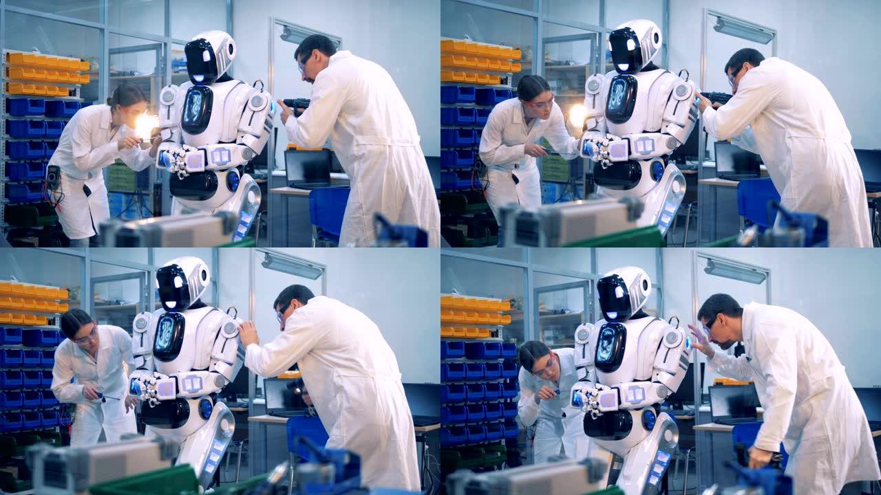两个工人让一个机器人工作。