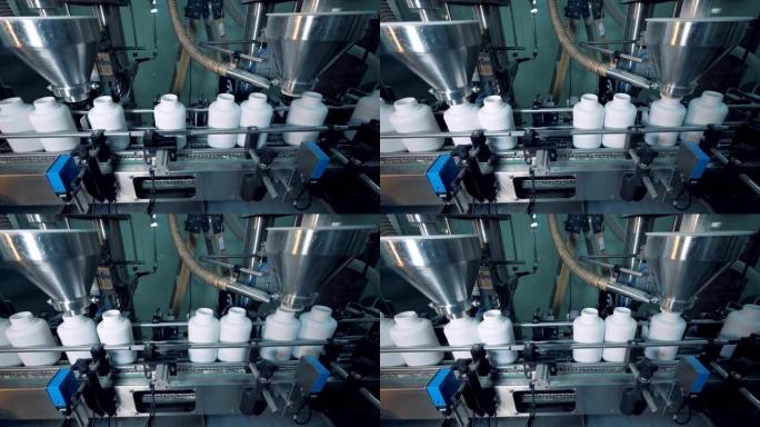 工作设备在移动输送机上灌装瓶子，自动化生产线。