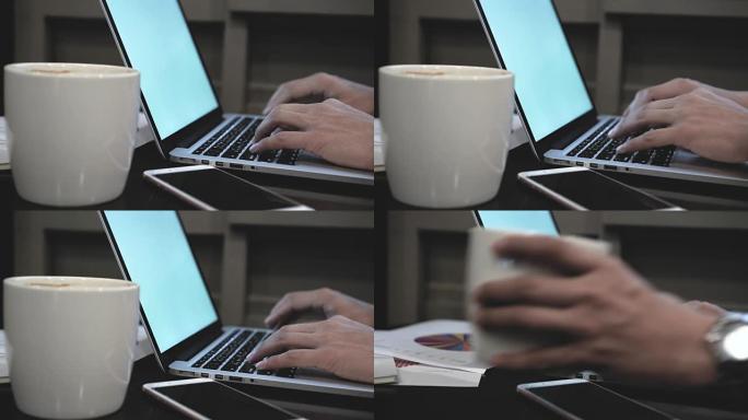 4k镜头场景特写亚洲商人与白屏笔记本电脑一起工作，在咖啡馆喝咖啡，生活方式和休闲概念