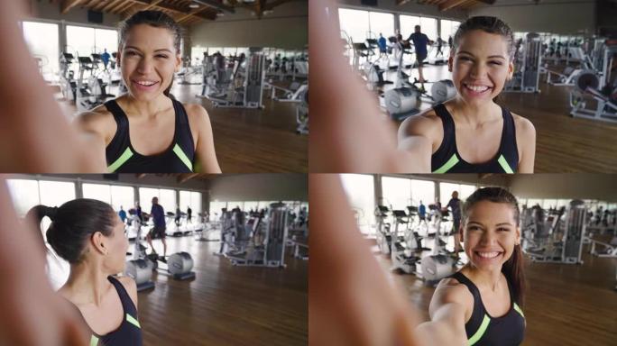 健身房里的女人拍照发送给朋友或在社交网络上拍照，并在微笑时拍照。