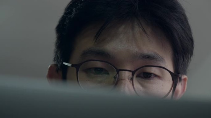亚洲男子通过在家中的笔记本电脑屏幕上学习班级
