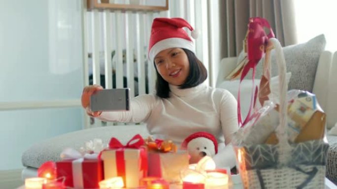 年轻女子在圣诞节用手机和礼品盒庆祝