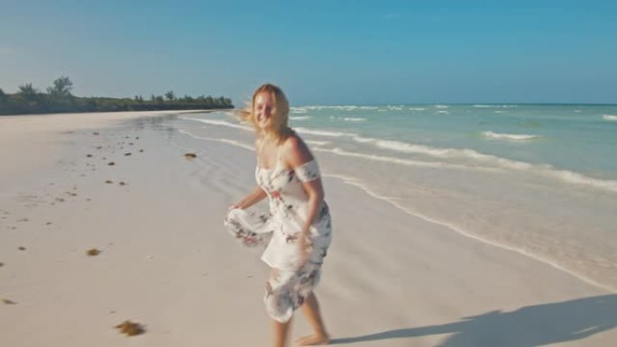 在美丽的海滩上奔跑的SLO MO欣喜若狂的女人