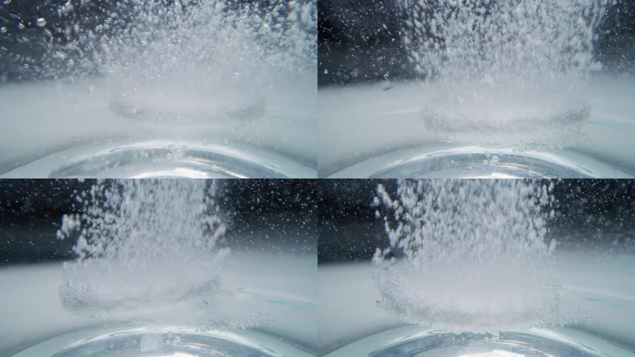慢动作微距泡腾片溶解在一杯水中。