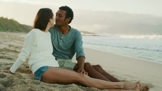 夫妻在日落时在海滩上亲吻感到舒适