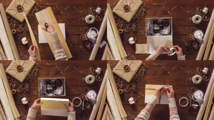 女人的手在礼品盒中包装复古相机并装饰
